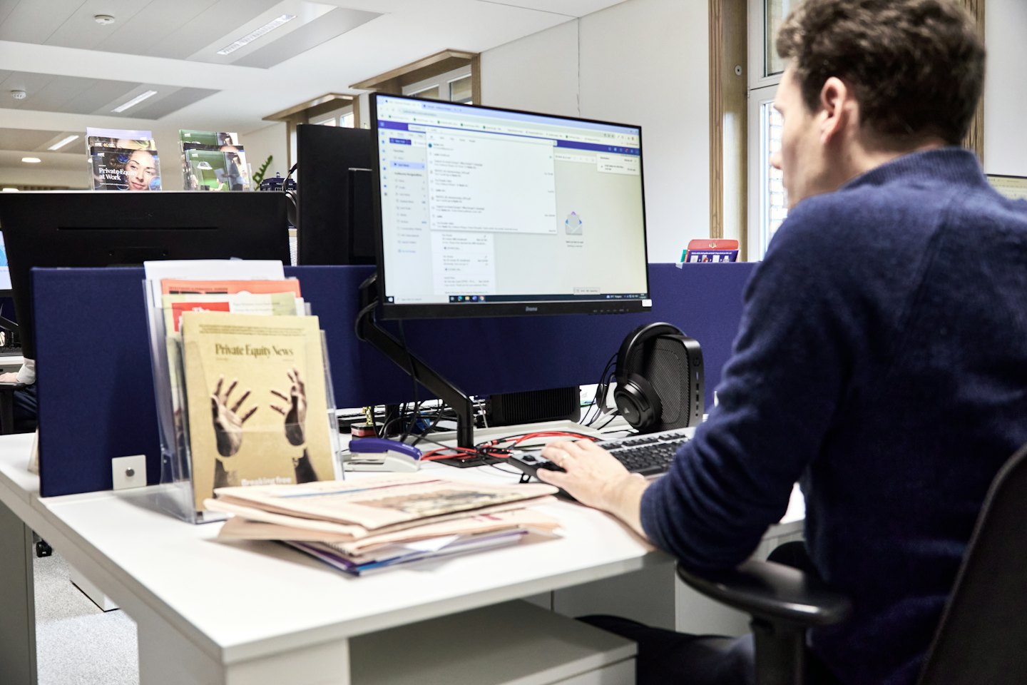 Man working on a laptop in a modern office.